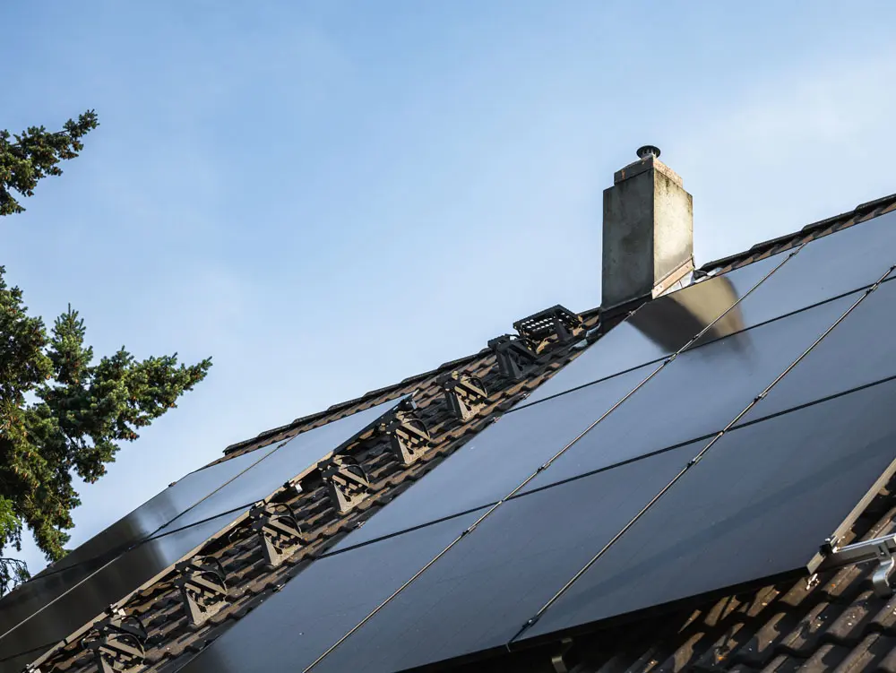 Infravoltaic Solaranlage mit Full-Black-Modulen auf einem dunklen Hausdach.