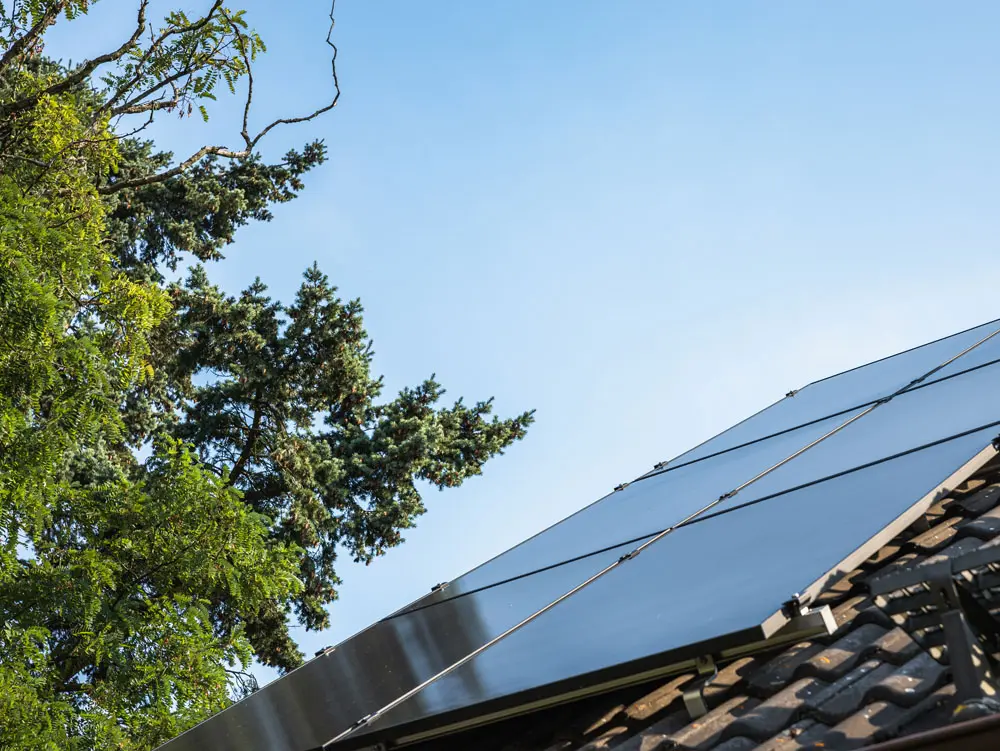 Fertig installierte Infravoltaic Solaranlage auf einem dunklen Hausdach.
