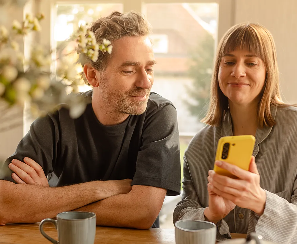 Frau zeigt Mann Infravoltaic App auf Handy