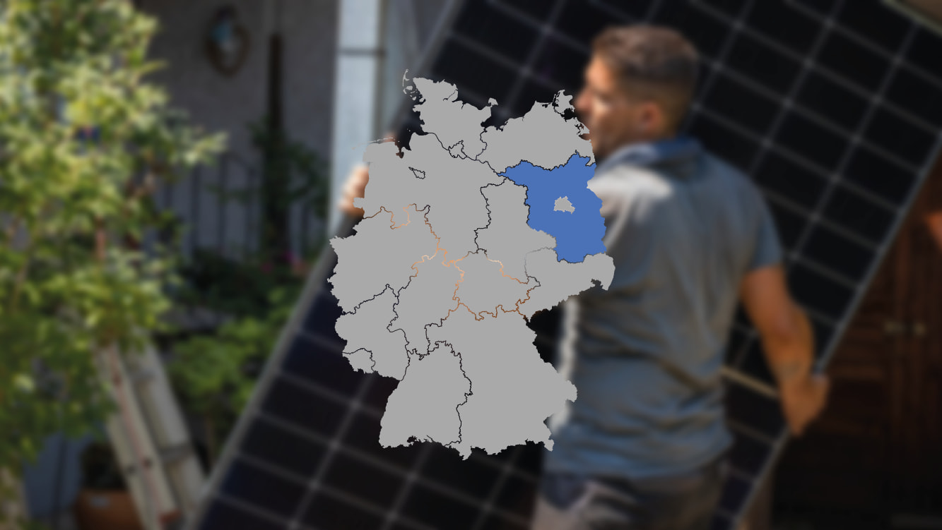 Solarmonteur mit Solarmodul verschwommen im Hintergrund und Deutschlandkarte im Vordergrund, wo Brandenburg blau markiert ist, um die Photovoltaik-Förderung dort zu zeigen