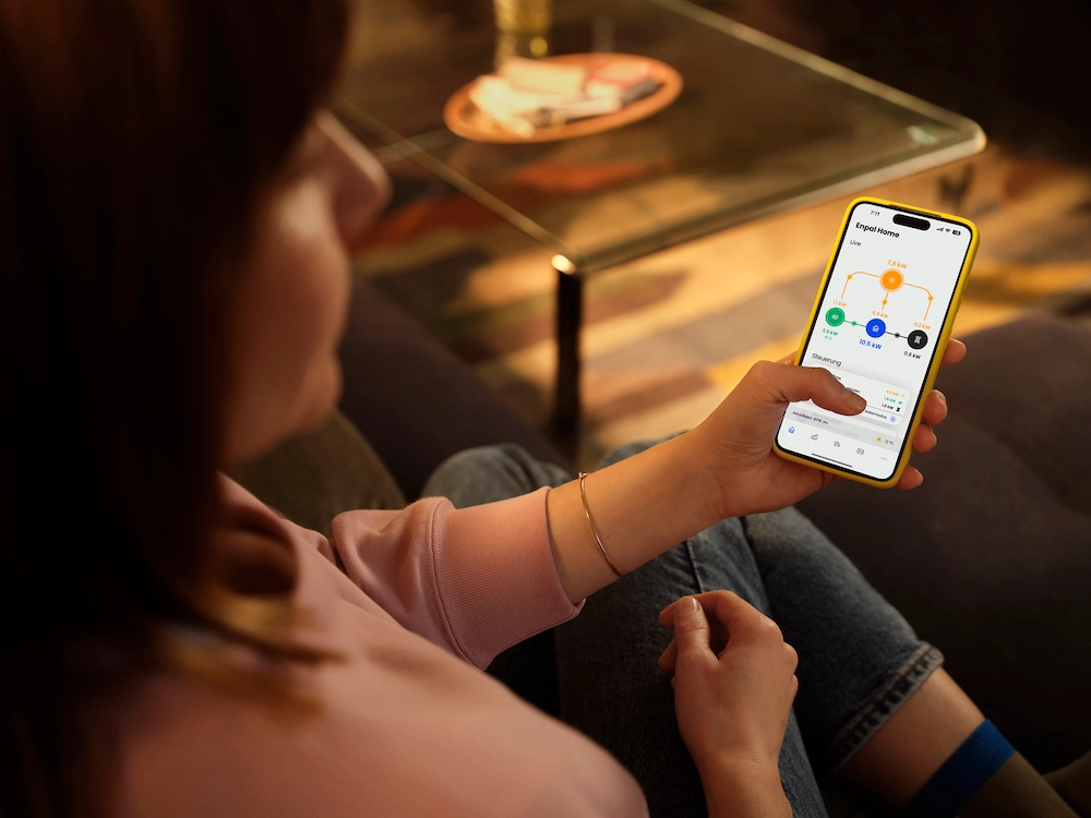Frau mit einem Handy in der Hand, auf dem die Infravoltaic App zu sehen ist