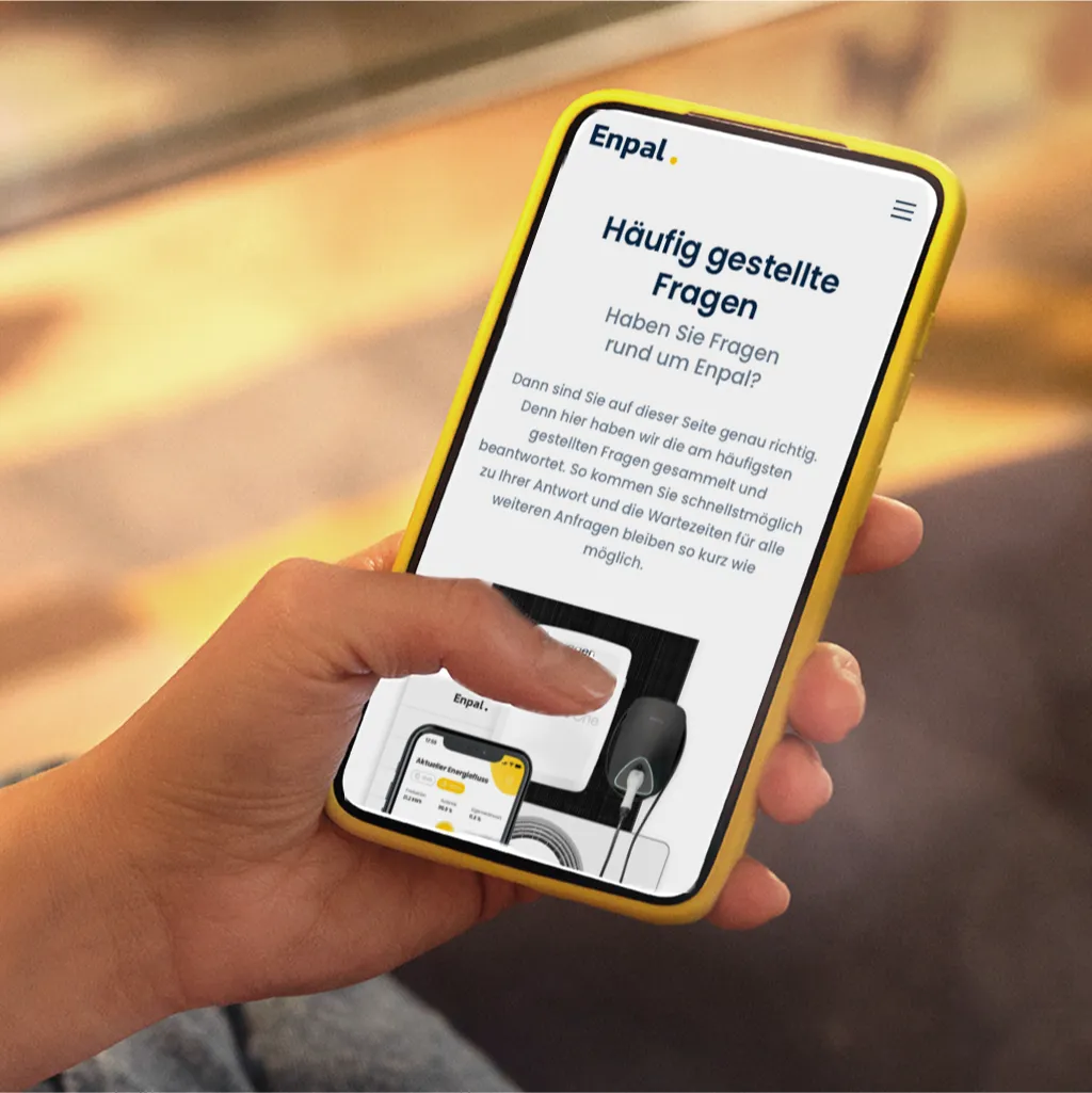Hand mit Handy und der Infravoltaic FAQ-Seite