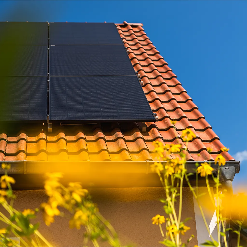 Hausdach mit Infravoltaic PV-Anlage und blauem Himmel