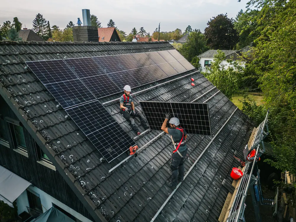 Zwei Solar-Monteure bei der Installation einer Infravoltaic Solaranlage mit Speicher.