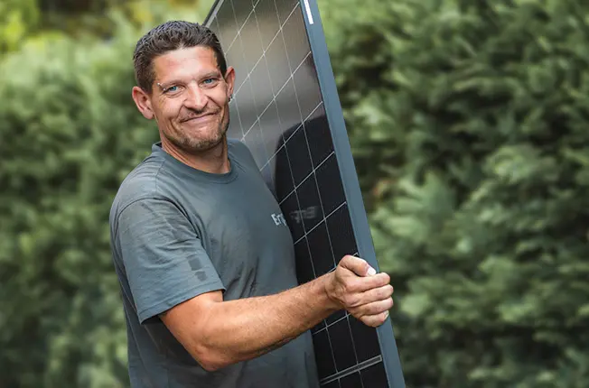 Infravoltaic Handwerker mit Solarmodul in der Hand