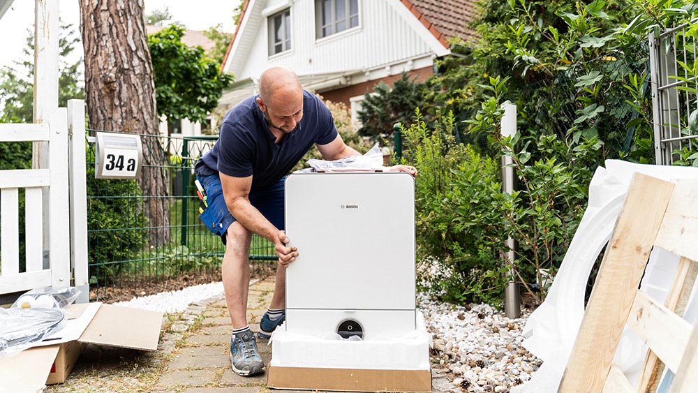 Infravoltaic Monteur packt eine Wärmepumpe aus