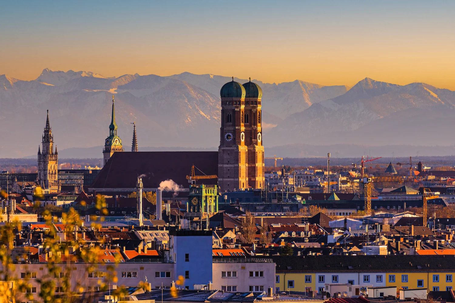 Ansicht von München mit Frauenkirche und den Alpen im Hintergrund