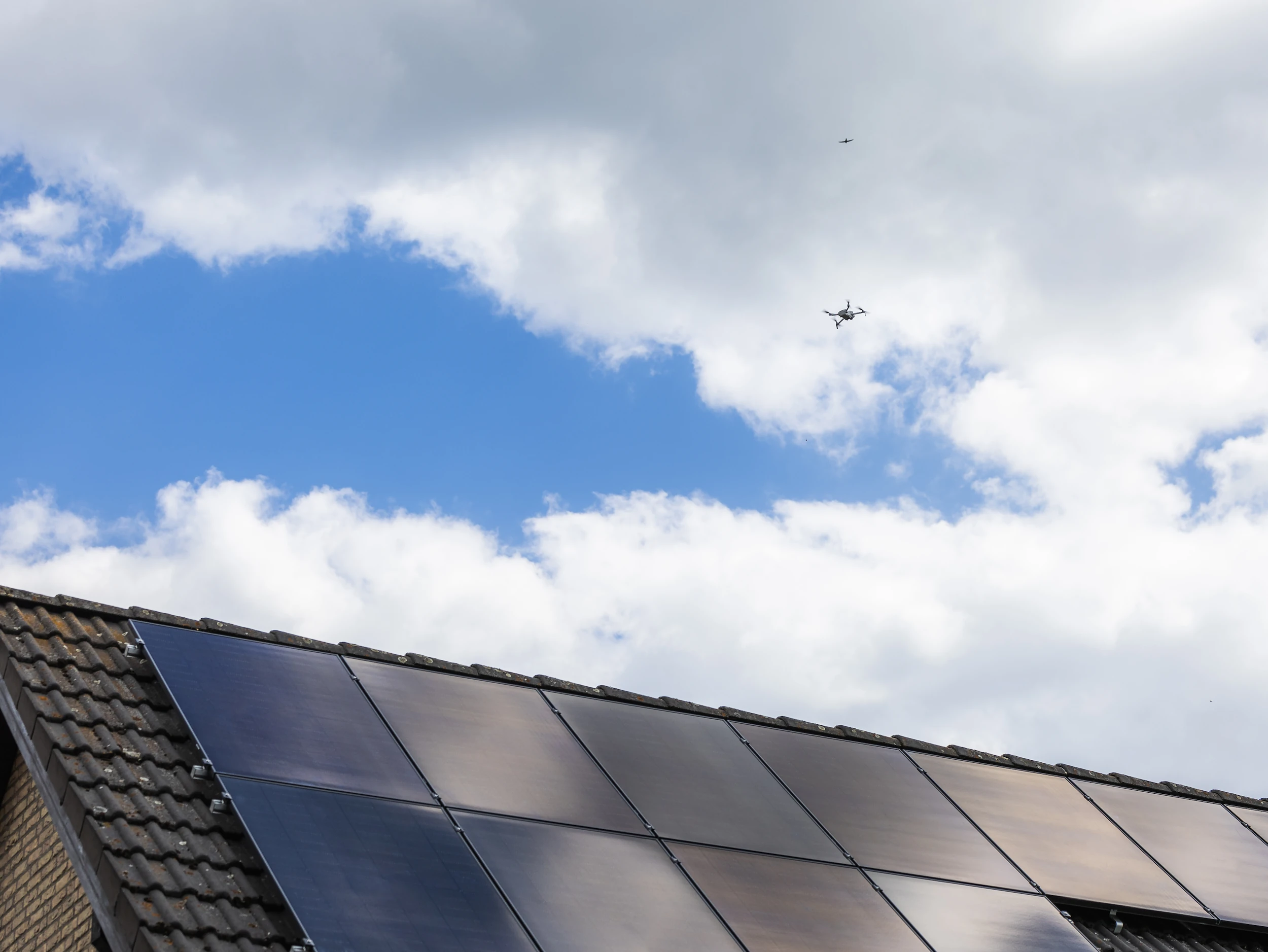Installierte Infravoltaic PV-Anlage auf dunklem Hausdach mit bewölktem Himmel im Hintergrund