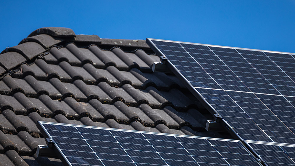 Fertig installierte Infravoltaic Solaranlage auf einem dunklen Hausdach.