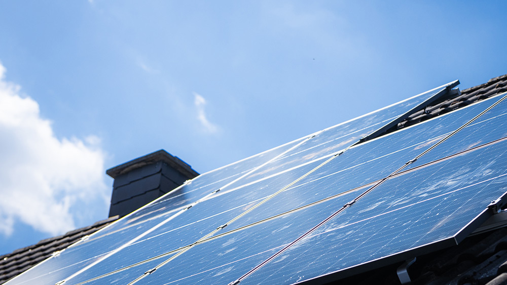 Fertig installierte Infravoltaic Solaranlage auf einem dunklen Hausdach.
